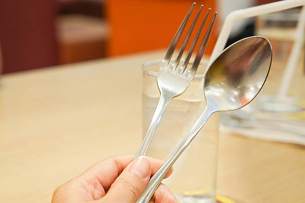 istock hold spoon and fork with left hand in restaurant background 610414000