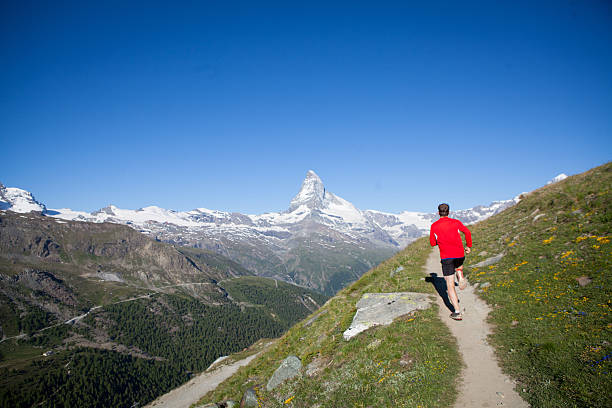 istock Man running along a swiss mountain trail 610414906