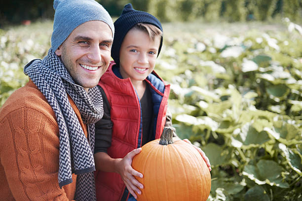 istock Father and son in the pumpkin field 610419448