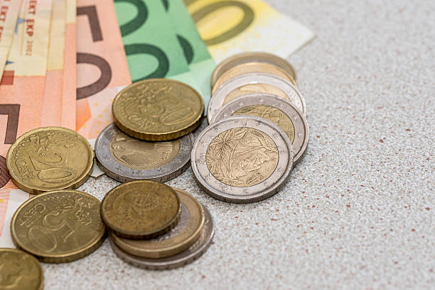 istock euro banknotes with coins on desk 610419472