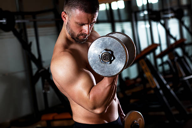 istock Man exercising with dumbbells in the gym. 610420104