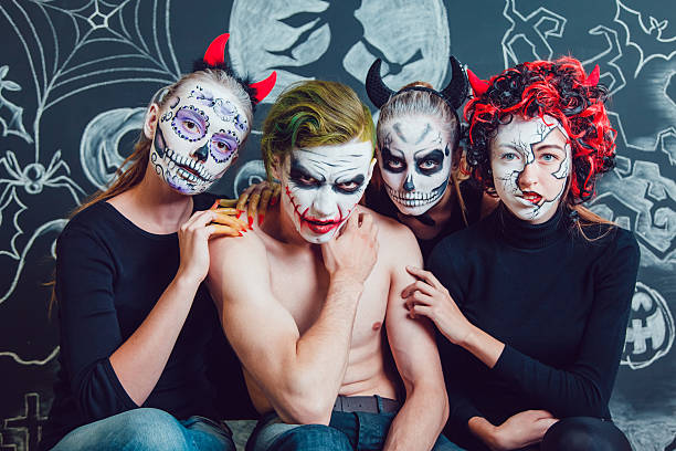 istock Three girls and a guy with Halloween face art on 610420438