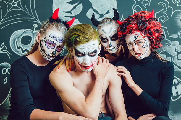 istock Three girls and a guy with Halloween face art on 610420622