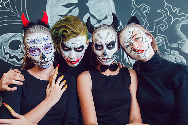 istock Three girls and a guy with Halloween face art on 610420924