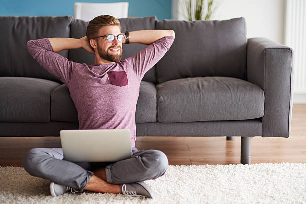 uomo con buone vibrazioni seduto sul pavimento - comfortable relaxation sofa men foto e immagini stock