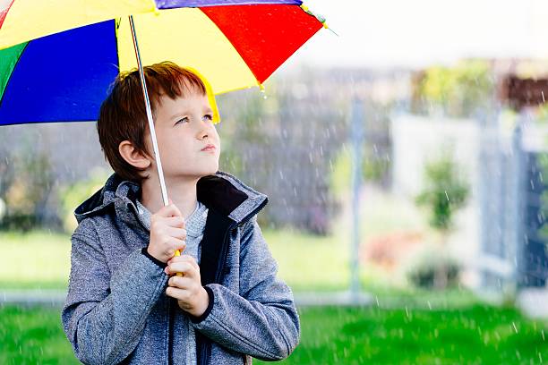 istock Seven years old boy standing at the rain 610421978
