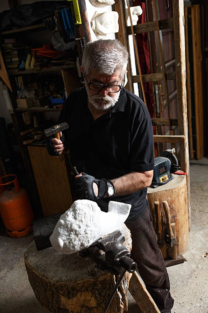 istock Senior sculptor working on his sculpture 610424374