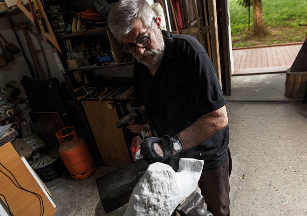 istock Senior sculptor working on his sculpture 610424580