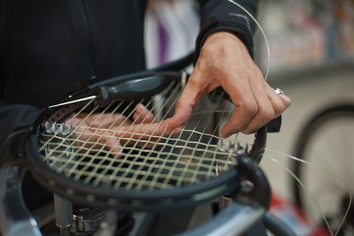 Primer plano de las manos del larguero de tenis haciendo encordamiento de raquetas photo