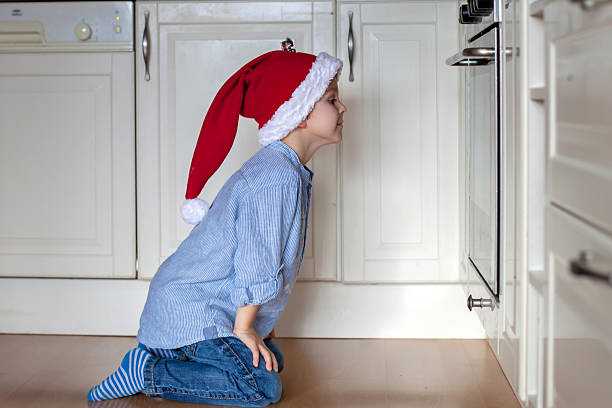 istock Curious little boy, watching ginger bread cookies in the oven 610429184