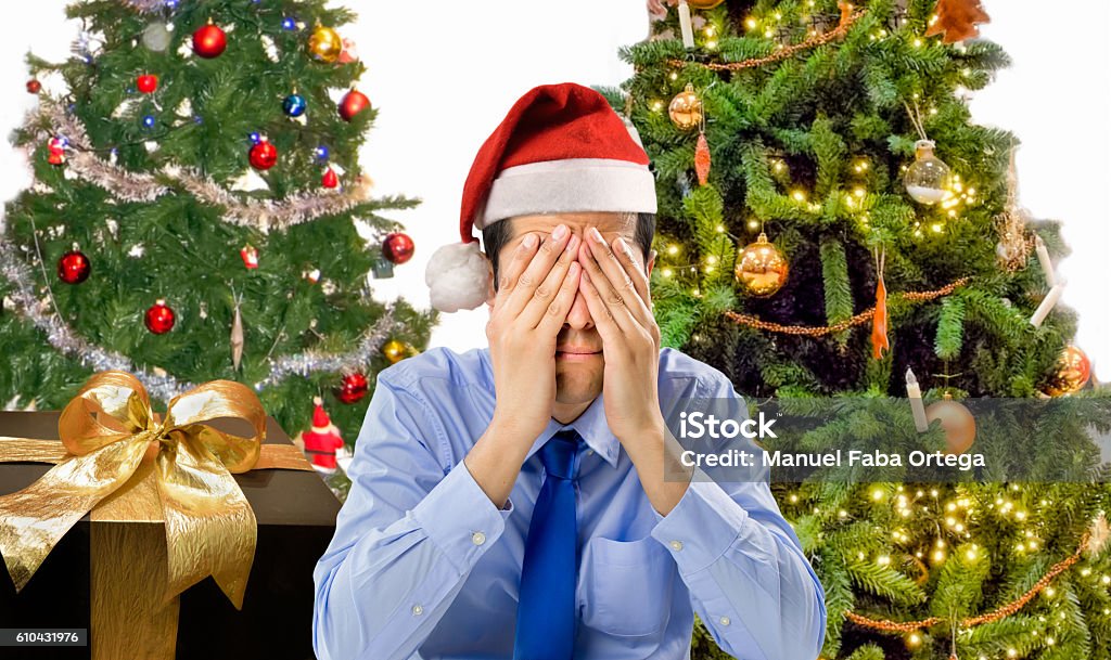 Christmas holiday stress Stressed man is shopping gifts for christmas with red santa hat angry and distressed Emotional Stress Stock Photo