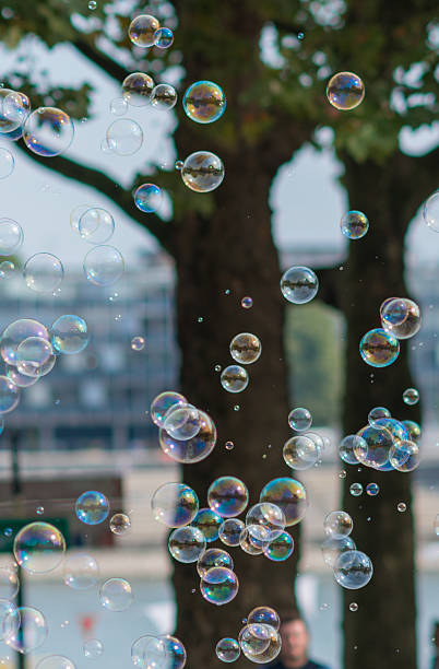 istock soap bubbles flying in front of trees in sunlight 610431986