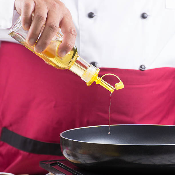istock Chef pouring vegetable oil to the pan 610432228
