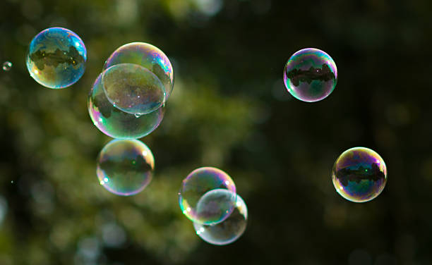 istock soap bubbles flying in front of trees in sunlight 610432582
