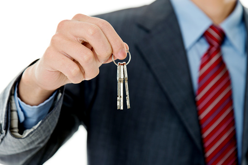 Businessman in suit handing key