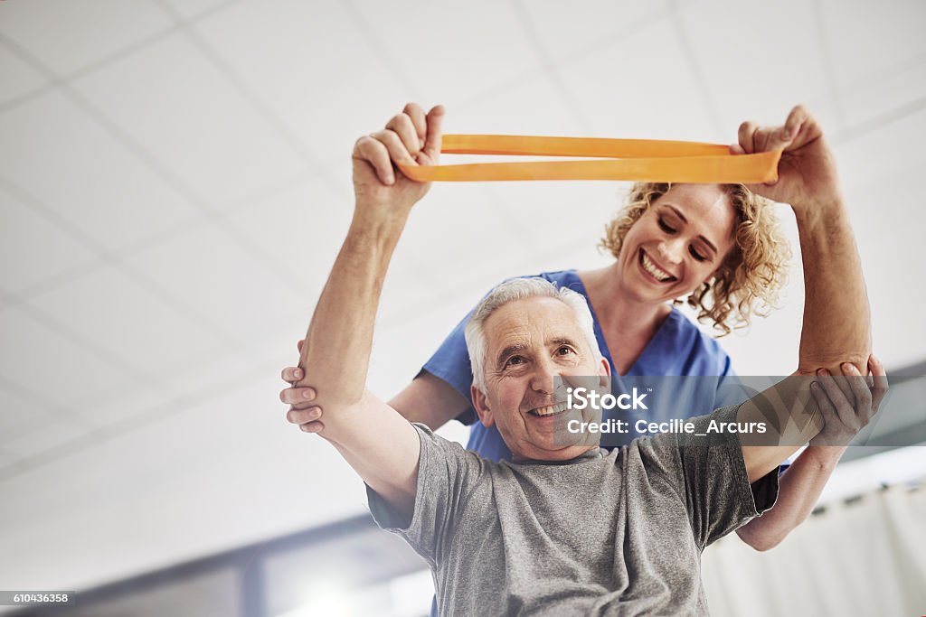 She'll have him rehabilitated in no time Shot of a female physician working with a senior patient in a nursing home Physical Therapy Stock Photo