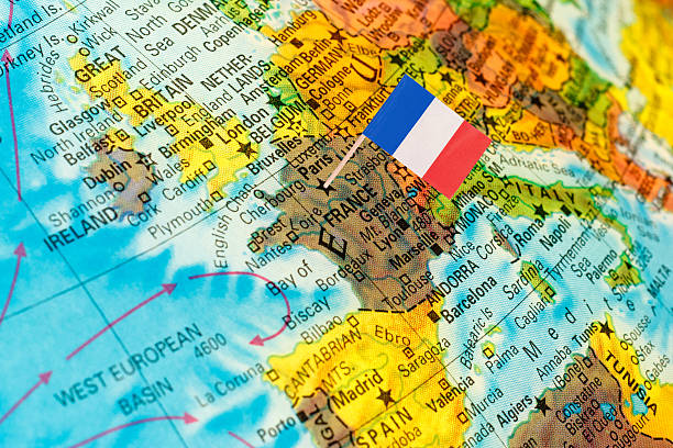 map with miniature flag of France .Selective focus on French Flag. Backlit lighting,
