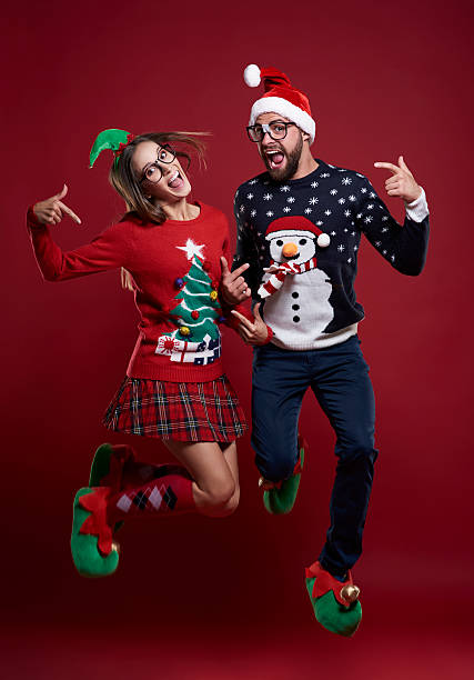 Christmas couple jumping very high Christmas couple jumping very high christmas nerd sweater cardigan stock pictures, royalty-free photos & images