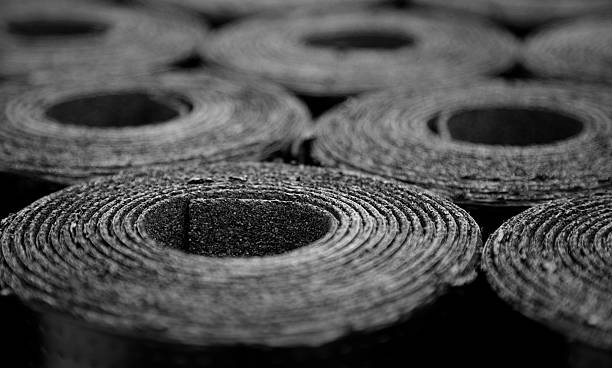 Roofing felt. Rolls of Bitumen Closeup of Rolls of new black roofing felt or bitumen. Selective focus felt textile stock pictures, royalty-free photos & images