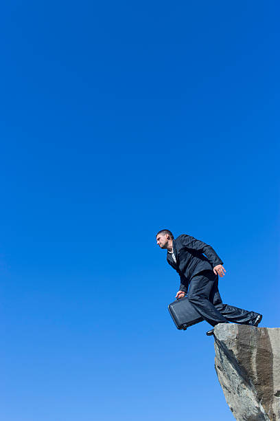 istock Jumping man with a diplomat from a cliff. 610438456