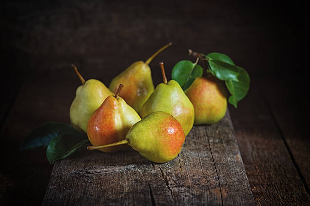istock Ripe yellow pears lying on a wooden serface 610440388