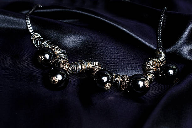 istock necklace with black beads on silk background 610440754