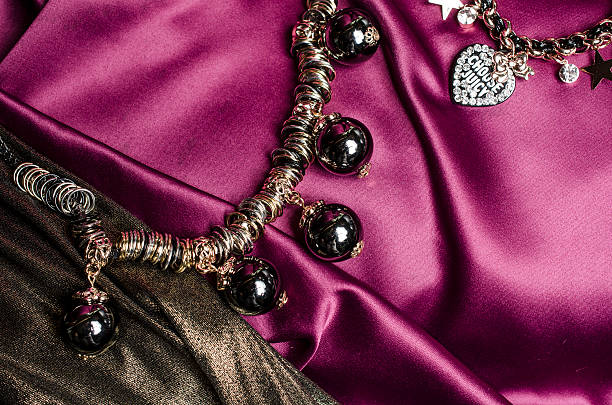 istock necklace with black beads and bracelet  on silk background 610441594