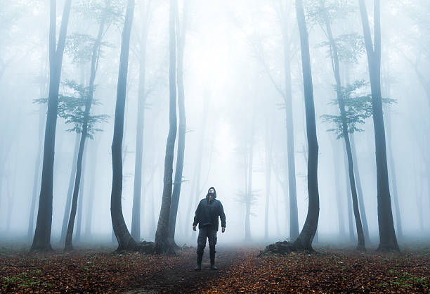 istock Dark horror man in creepy foggy forest 610442892