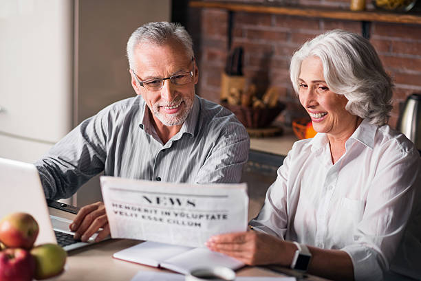 istock Likable old couple reading newspaper at the kitchen table 610443726