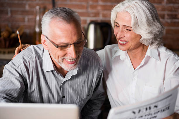 istock Elderly grey couple together at the laptop 610443880