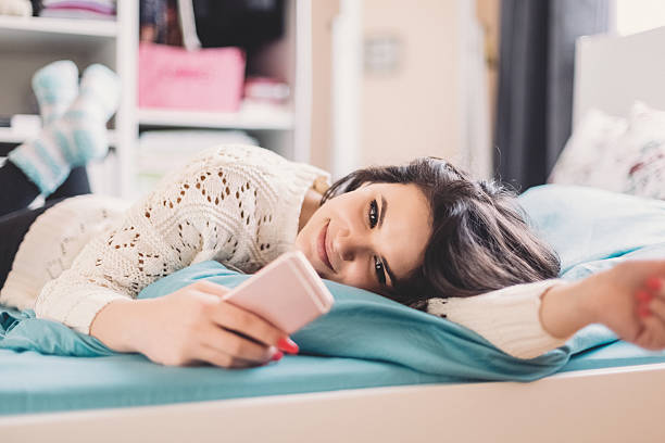 adolescente rilassata a letto - appuntamento online foto e immagini stock