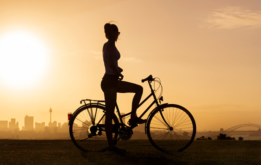 Girl on old bicycle at sunset