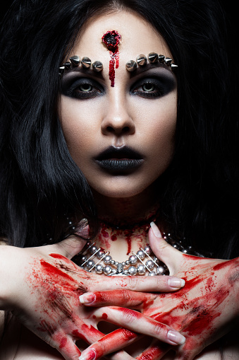 Demon girl with a bullet in the head and her throat cut. An image for Halloween. Photos shot in studio