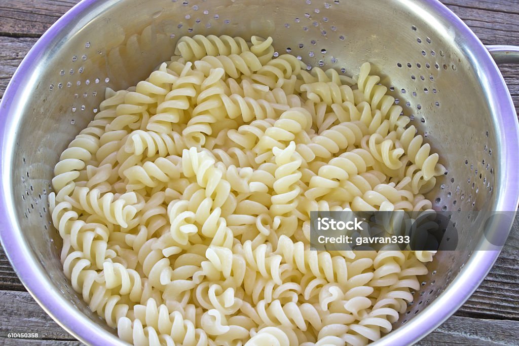 Fresh cooked fusilli pasta in strainer on table Cereal Plant Stock Photo