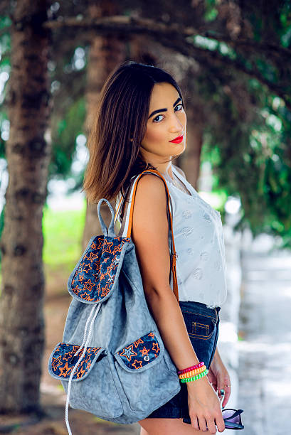 istock Girl brunette in summer in the park with a backpack 610452700