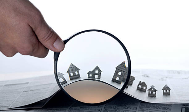 istock Paper house under a magnifying lens 610453820