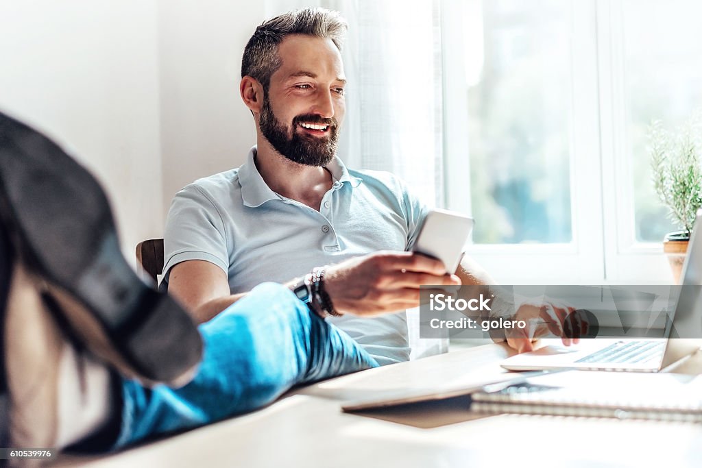 lucky bearded man makes business in the web at home Stock Market and Exchange Stock Photo