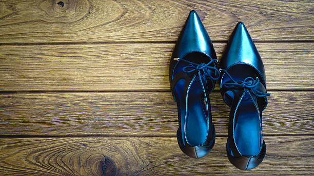 istock Black high heel shoes on wooden background 610541042