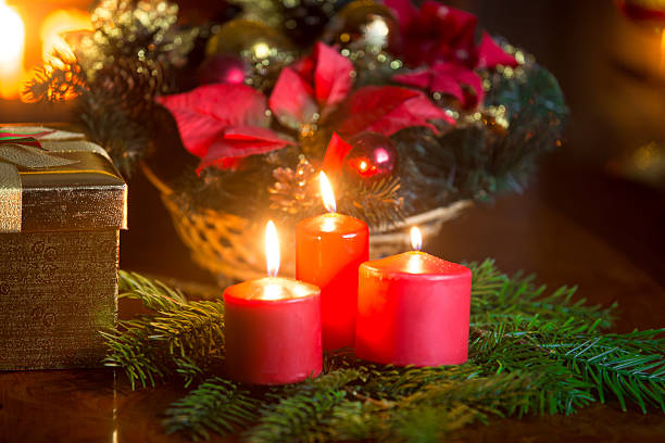 Christmas decorative wreath with burning red candles on table at living room