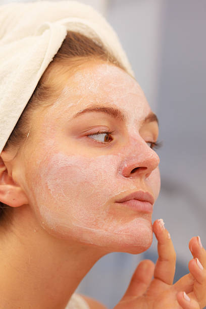 istock Woman applying mask cream on face in bathroom 610544966