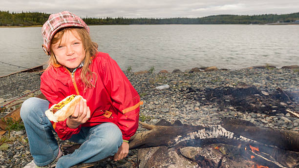 istock Girl eating hotdog 610545008