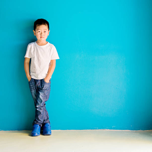 istock Chinese little boy against wall 610545190