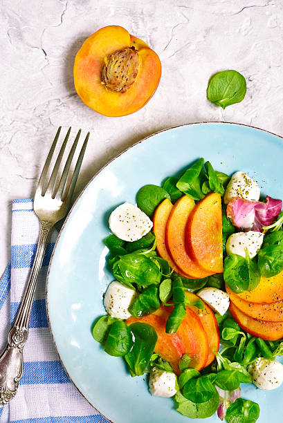 istock Fresh peach salad with corn and mozzarella.Top view. 610545236