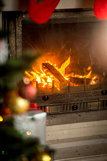 istock Fireplace with with burning wood logs decorated for Christmas 610545386