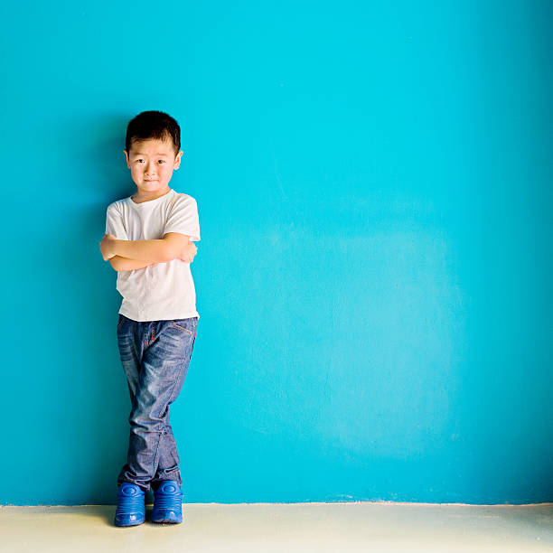 istock Chinese little boy against wall 610545824
