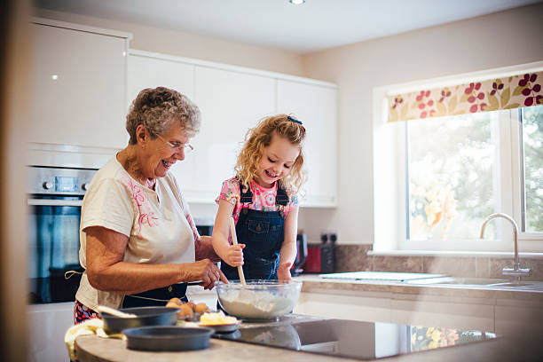 backen eines kuchens mit oma - grandmother cooking baking family stock-fotos und bilder