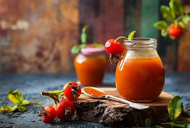 Rose hip jam in jar with fresh berries and leavesRose hip jam in jar with fresh berries and leaves