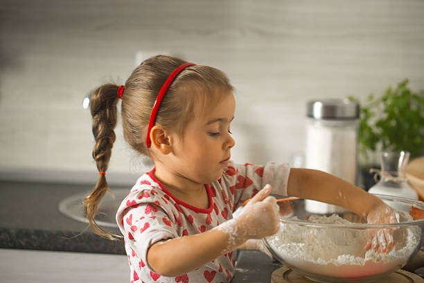 istock beautiful little girl Baker on kitchen 610550594