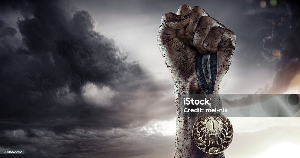 Sports background. Man's hand holding up trophy medal. Sport. Winner in a competition.  Trophy - Award Stock Photo