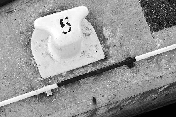 White port mooring bollard with number 5 label on it, black and white retro style photo